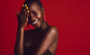 Smiling African woman with vivid makeup and bright yellow nails