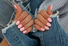 female hands with pink graphic matte manicure