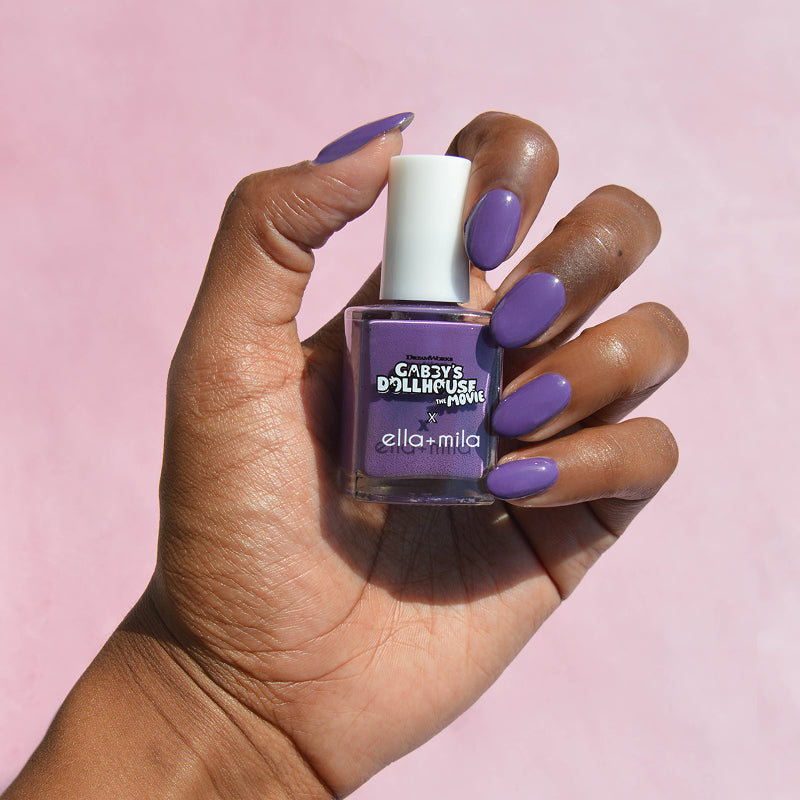 Gabby's Dollhouse Carlita's Violet Vroom purple nail polish on a deep skin tone, hand holding the bottle