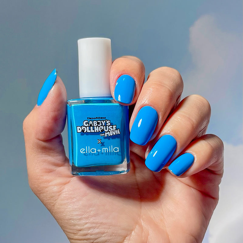 Gabby's Dollhouse CatRat Cat-i-tude sky blue nail polish manicure on a medium skin tone, holding the bottle