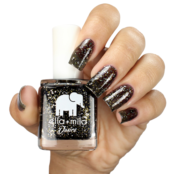 Black Tie Affair black tinted glitter nail polish on a medium skin tone, holding the bottle