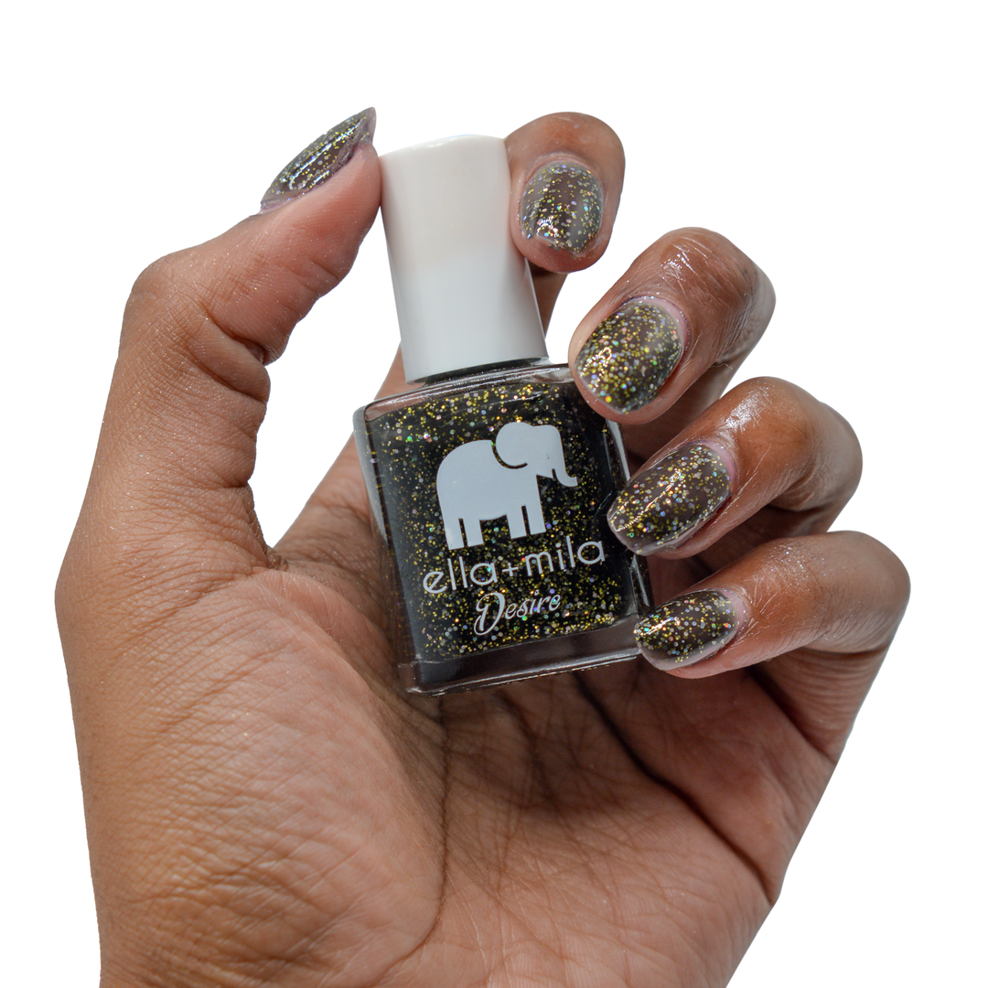 Black Tie Affair glitter nail polish on a deep skin tone, hand holding the bottle