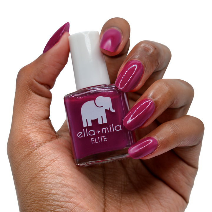 In Line for Wine merlot nail polish on a deep skin tone, hand holding the bottle