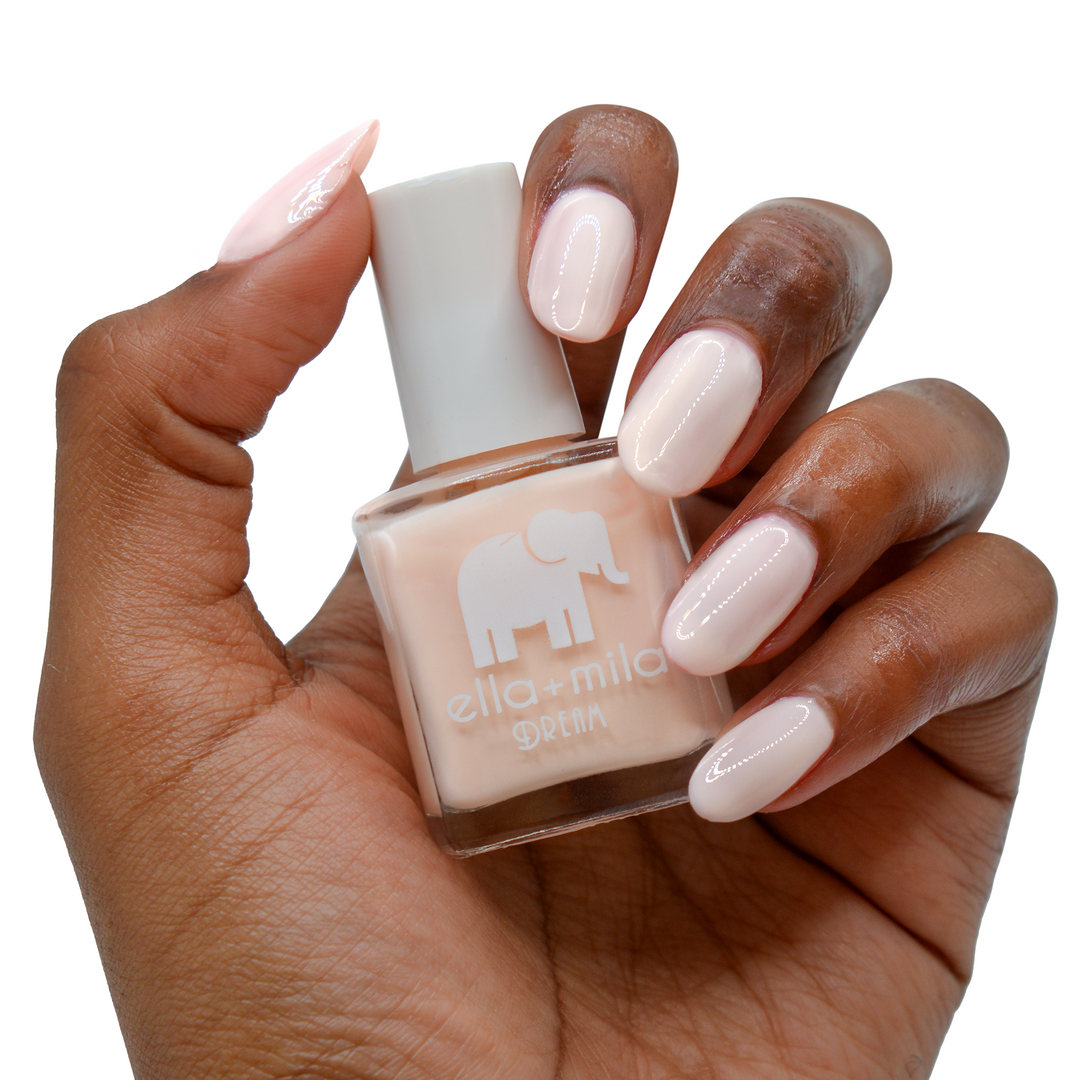 La La Land creamy nude pink nail polish on a deep skin tone, hand holding the bottle