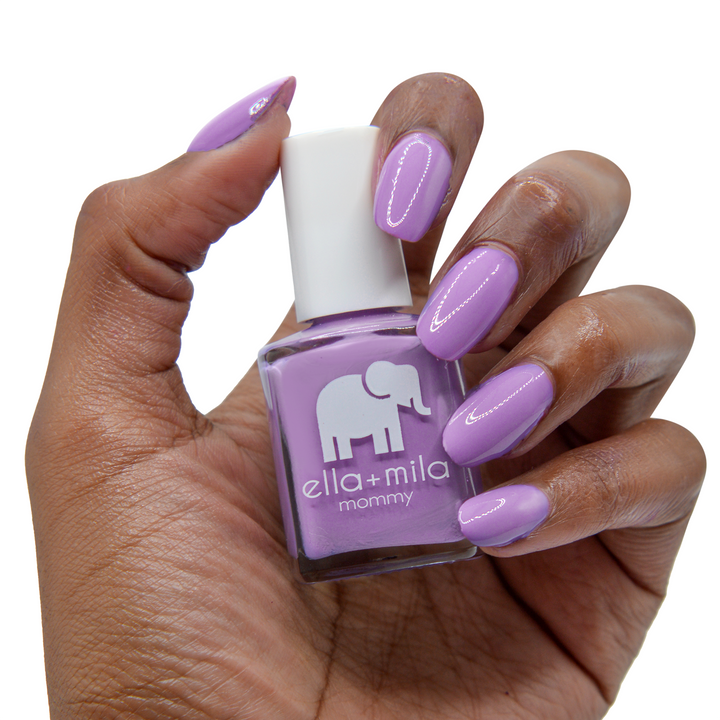 Lavender Fields lavender purple nail polish on a deep skin tone, hand holding the bottle