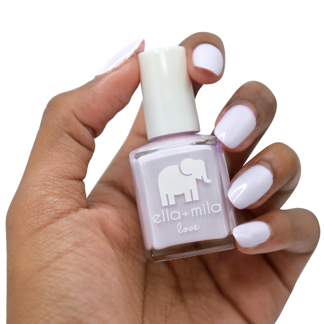 Lilac Luster pastel lilac nail polish on a deep skin tone, hand holding the bottle