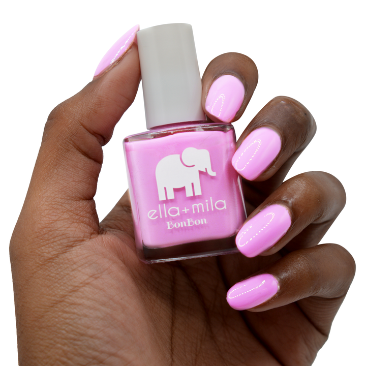 Macaruin My Diet pastel purple pink nail polish on a deep skin tone, hand holding the bottle