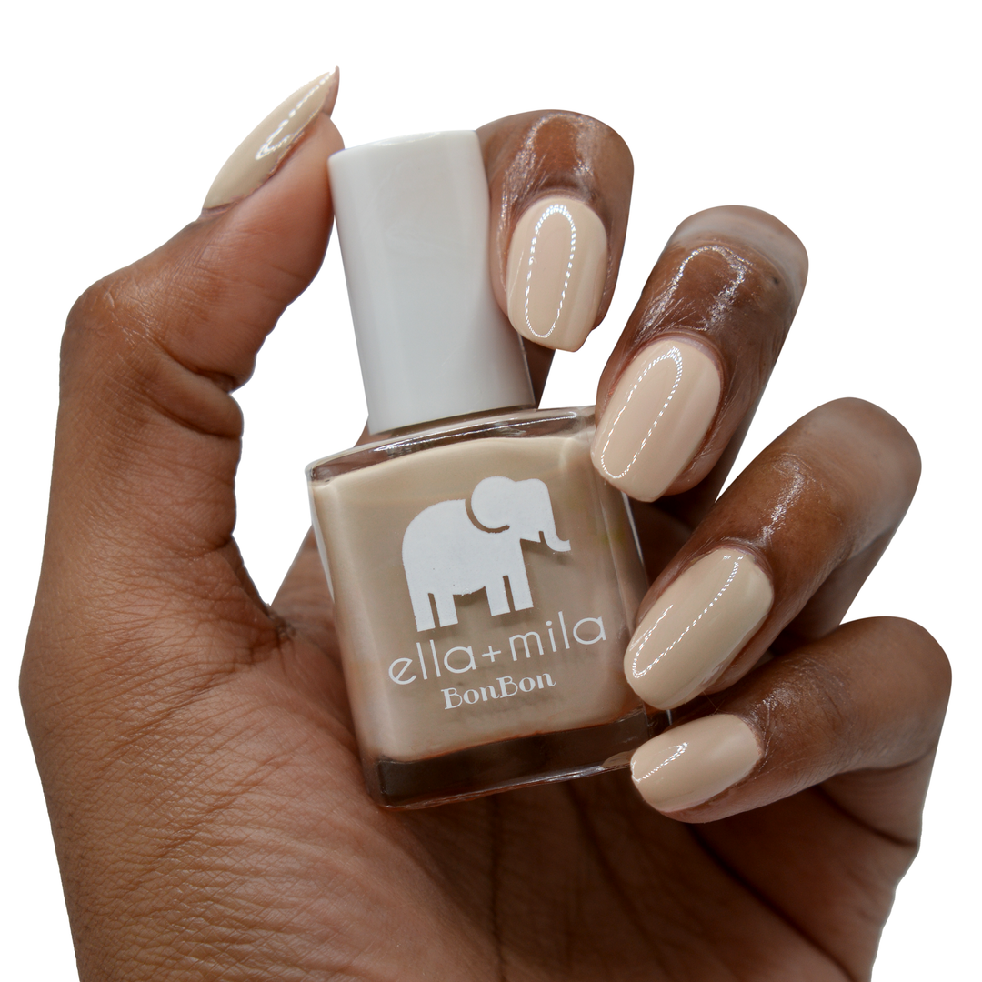 Mocha Dreams soft brown nail polish on a deep skin tone, hand holding the bottle