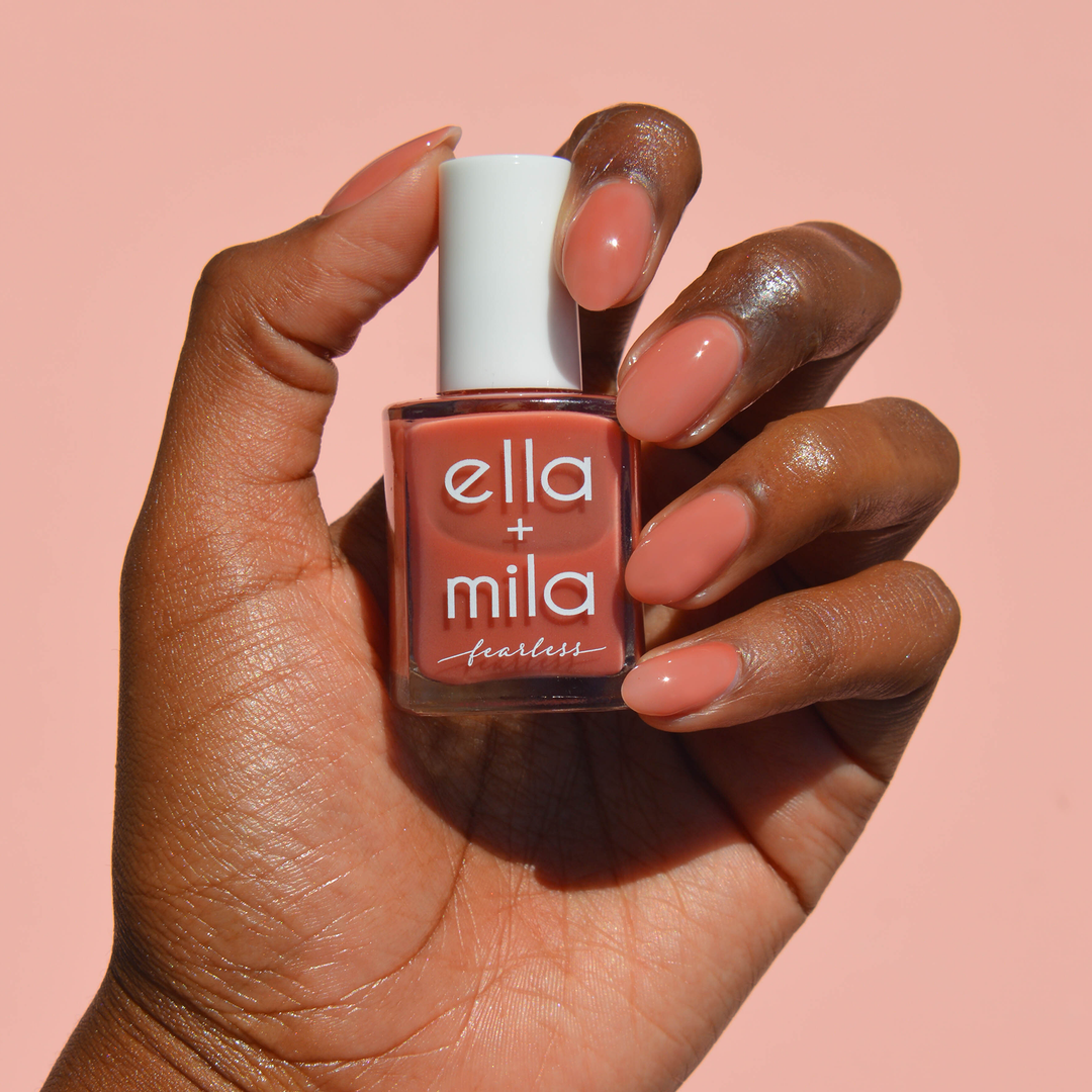 My Legacy milky dusty rose nail polish on a deep skin tone, hand holding the bottle