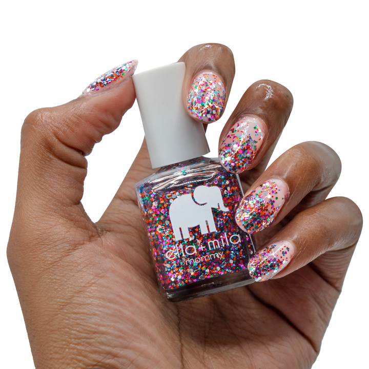 Party in a Bottle colorful glitter nail polish on a deep skin tone, hand holding the bottle