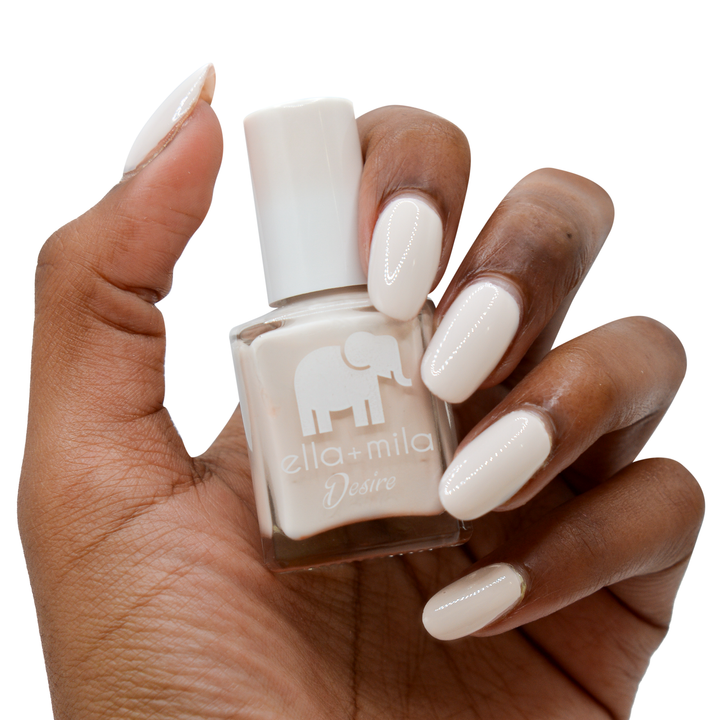 Stonehearted creamy grey nail polish on a deep skin tone, hand holding the bottle