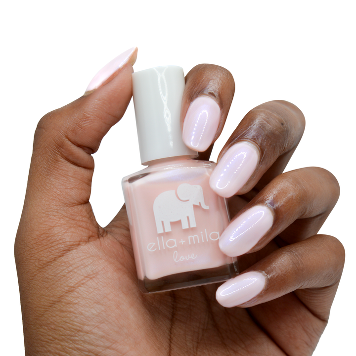 Stuck On You iridescent pink nail polish on a deep skin tone, hand holding the bottle
