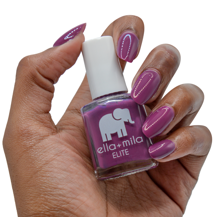 Take Off berry pink nail polish on a deep skin tone, hand holding the bottle