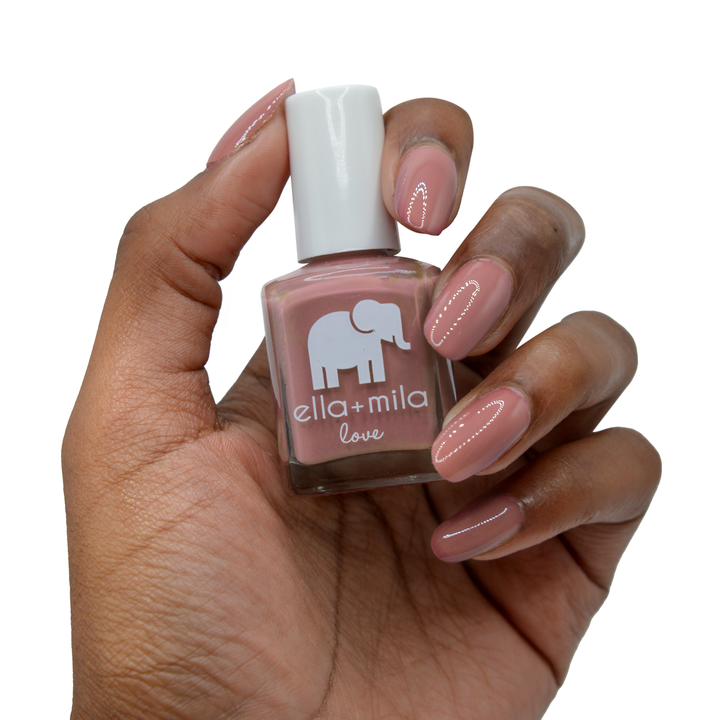 Til Forever rosy mauve nail polish on a deep skin tone, hand holding the bottle