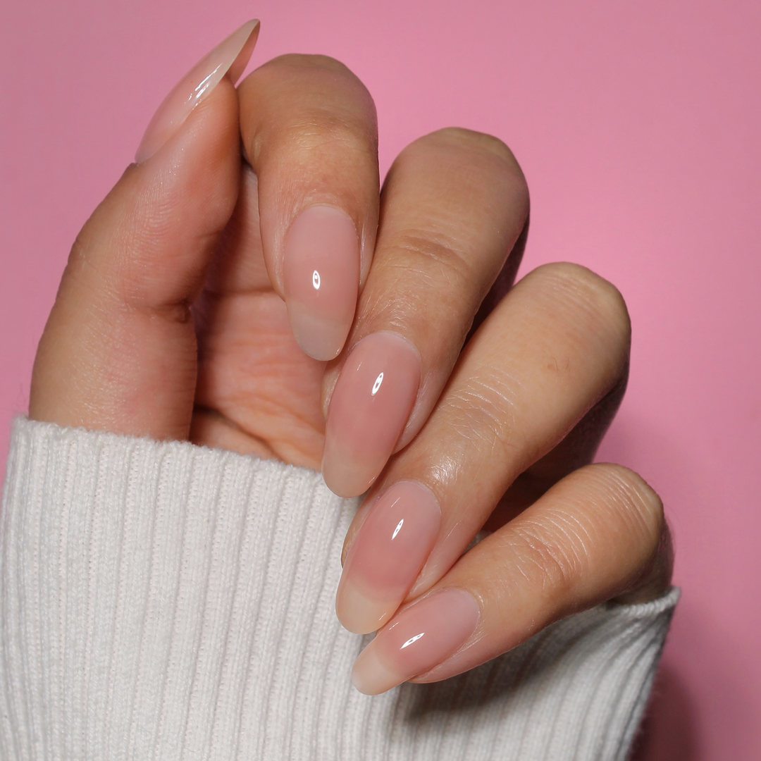 Unstoppable milky peach nail polish manicure on a light skin tone with a white sweater