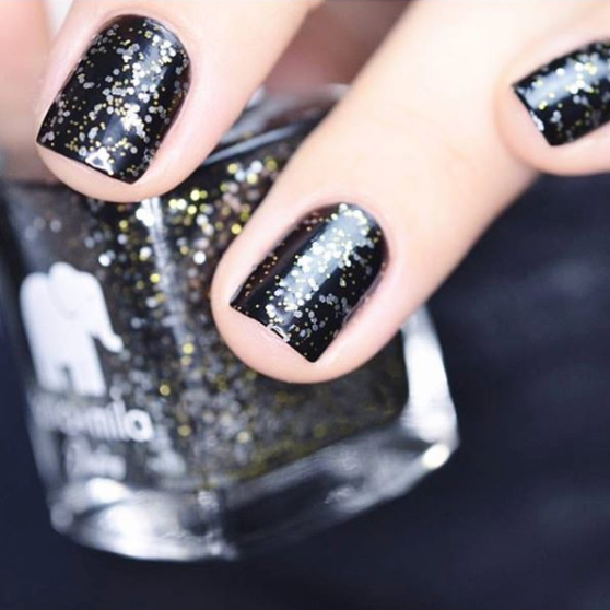 Black Tie Affair black and gold glitter nail polish close-up with the bottle