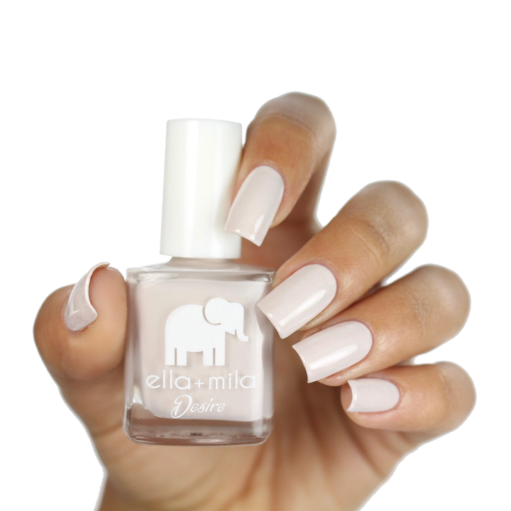 Stonehearted creamy grey nail polish on a medium skin tone, hand holding the bottle