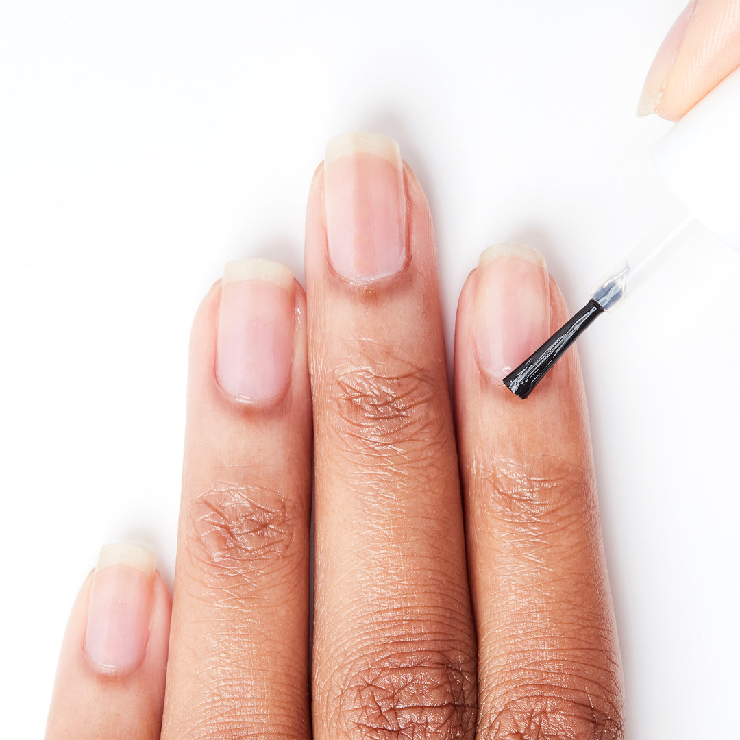 Applying Take It Off cuticle remover to a nail on a medium skin tone