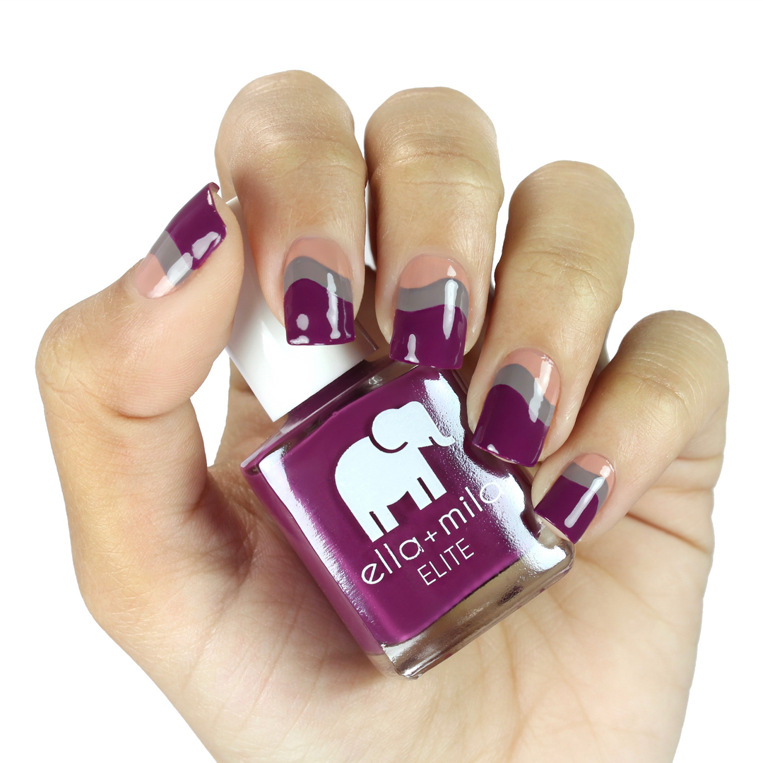 Take Off berry pink nail polish with a white accent nail, holding the bottle