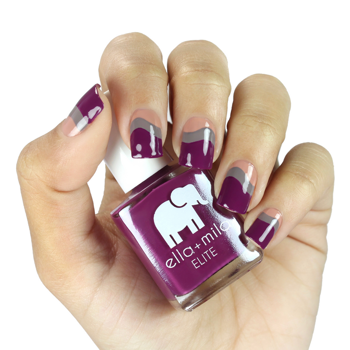 Take Off berry pink nail polish with a white accent nail, holding the bottle