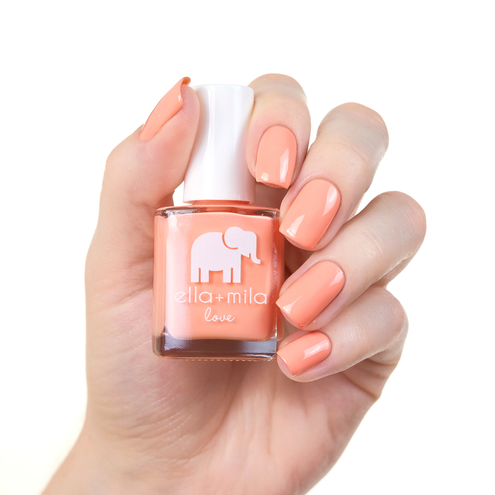 A Proposal light coral pink nail polish manicure on a light skin tone with the bottle