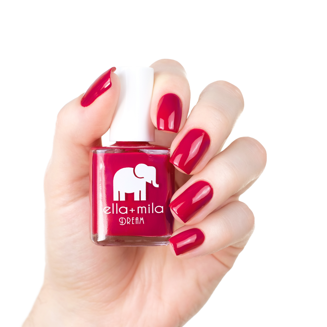 Bad Obsession crimson red nail polish manicure on a light skin tone with the bottle