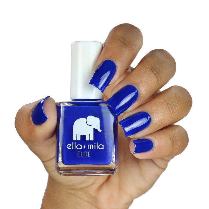 Bags Are Packed royal blue nail polish on a medium skin tone, hand holding the bottle