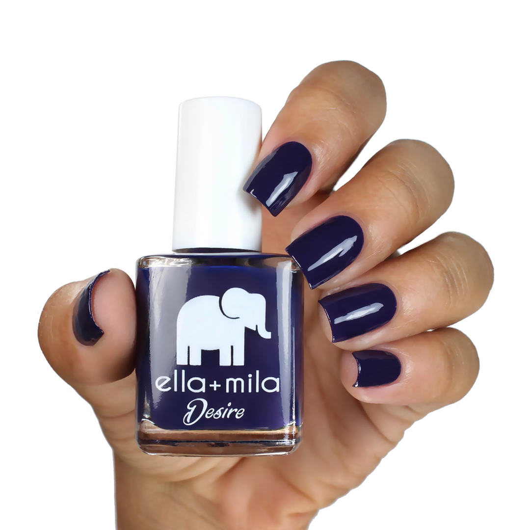 Bite Me deep purple nail polish on a medium skin tone, hand holding the bottle