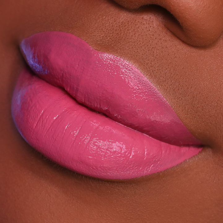 Blush rosy pink lipstick on lips, deep skin tone close-up