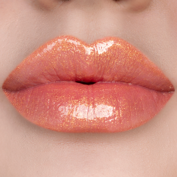 Bronze Babe golden bronze shimmer lip gloss on lips, light skin tone