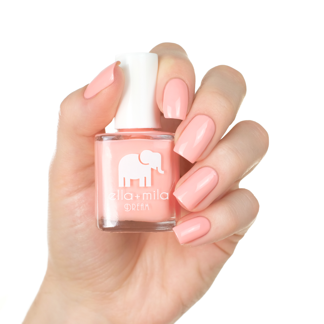 Bubble Trouble peachy pink nail polish manicure on a light skin tone with the bottle