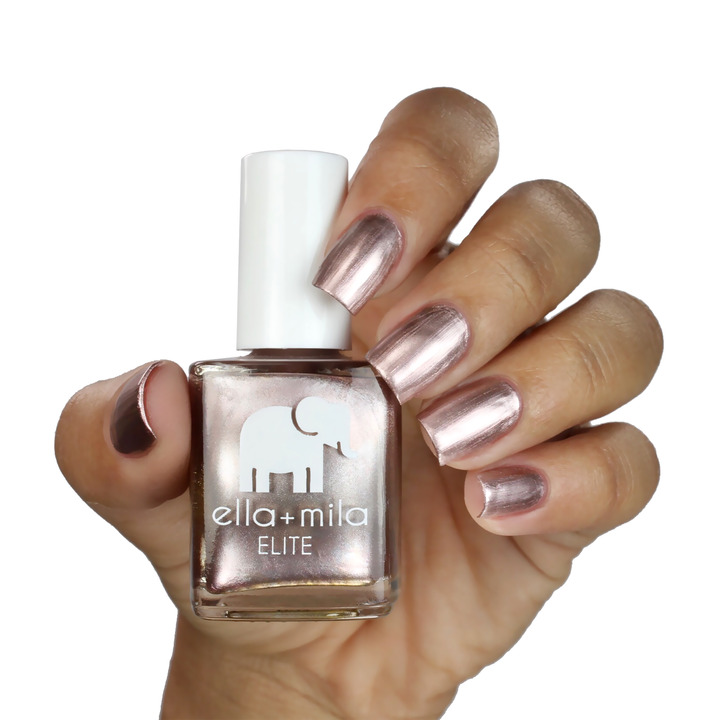 Champagne Pop metallic rose gold nail polish on a medium skin tone, hand holding the bottle