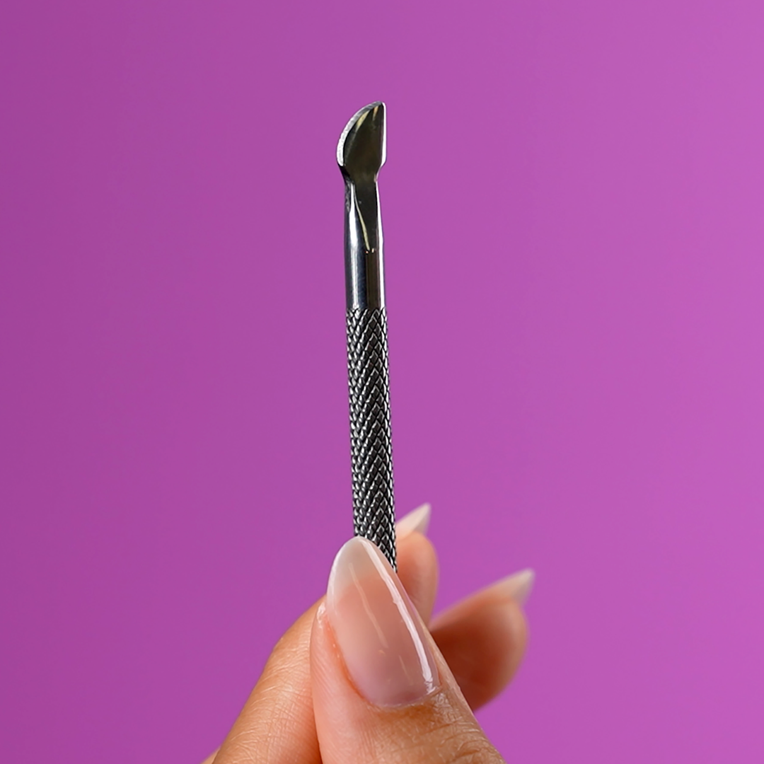 Close-up of the cuticle pusher tip pushing back a cuticle