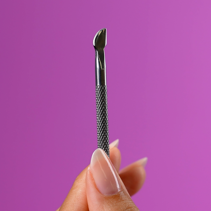 Close-up of the cuticle pusher tip pushing back a cuticle