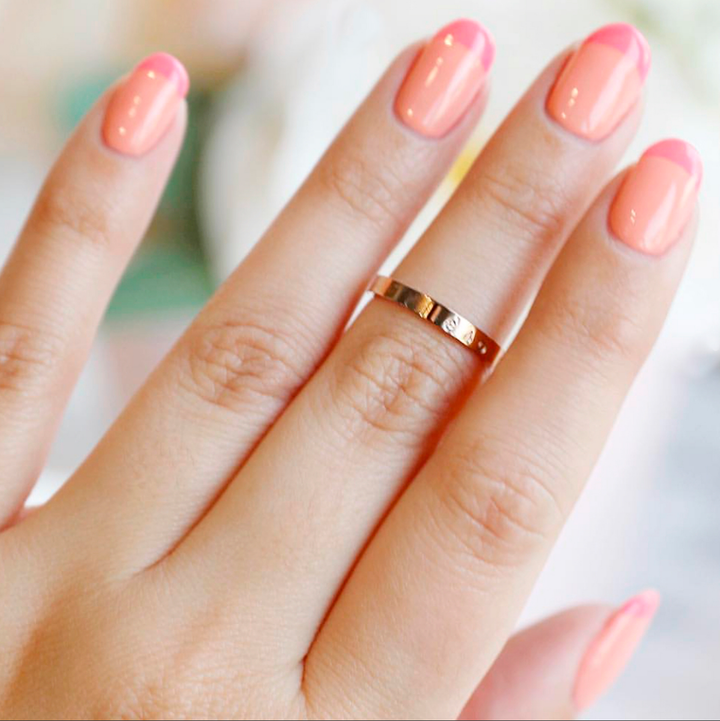 French Kiss peach coral nail polish manicure with a gold ring