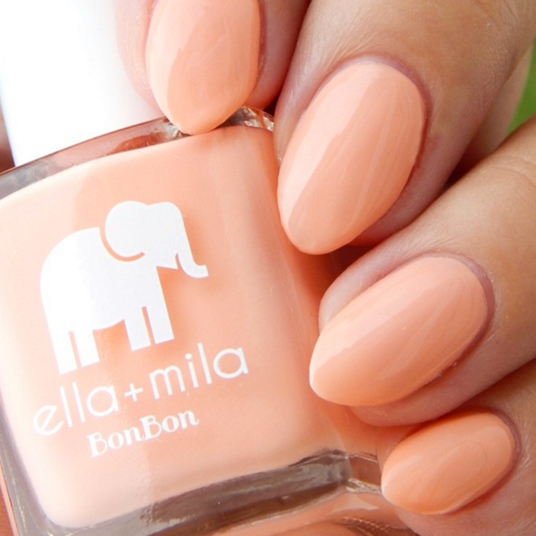 French Kiss peachy coral nail polish close-up with the bottle