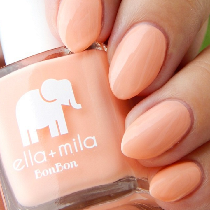 French Kiss peachy coral nail polish close-up with the bottle