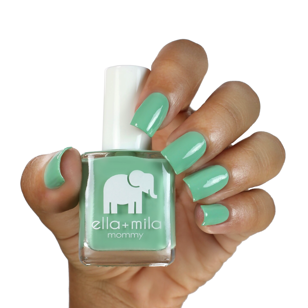I Mint It tropical mint nail polish on a medium skin tone, hand holding the bottle