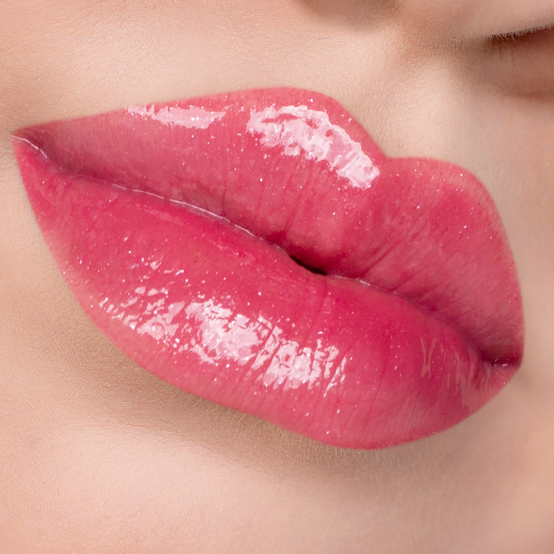 Just Cheeky berry pink lip gloss on lips, light skin tone close-up