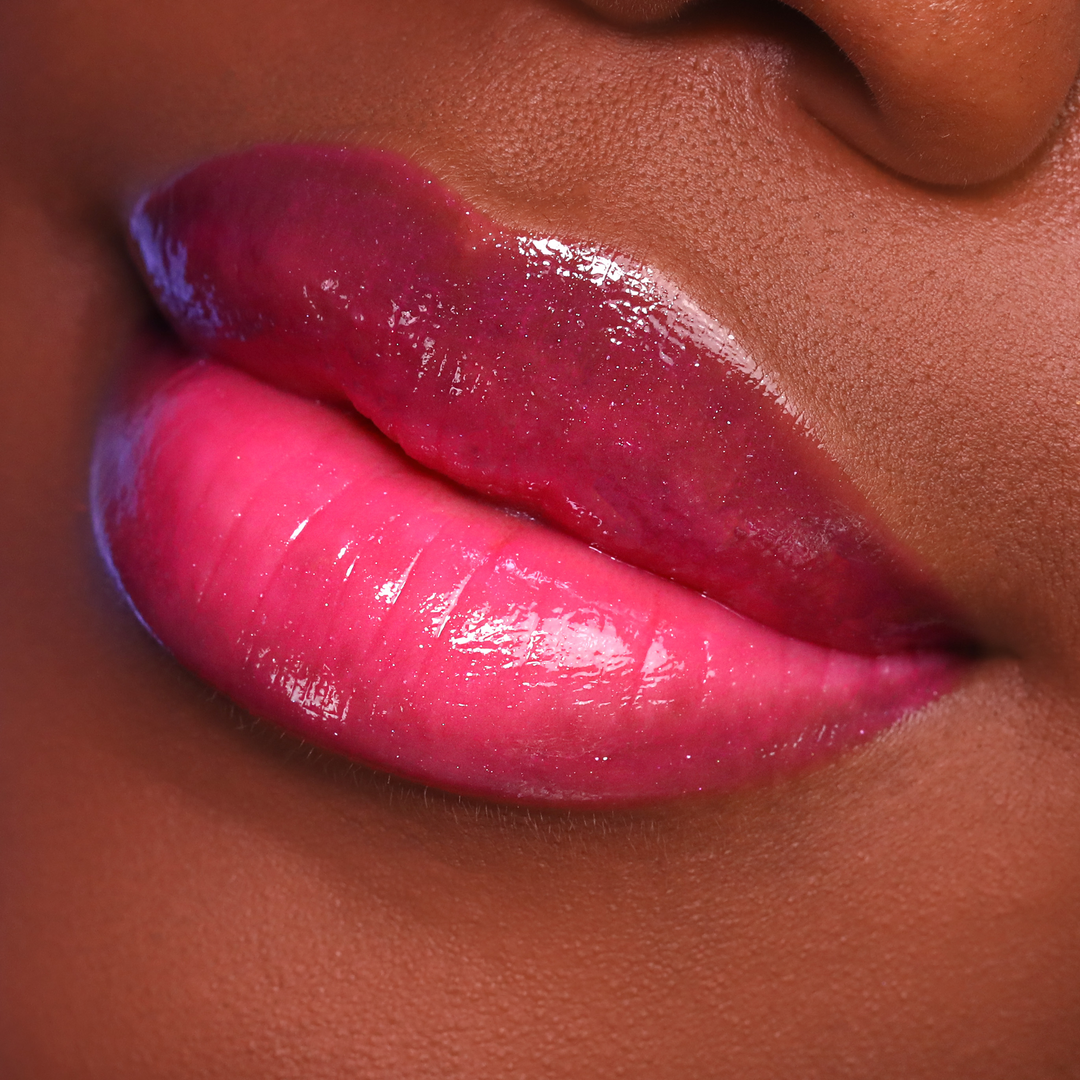 Just Cheeky berry pink lip gloss on lips, deep skin tone close-up