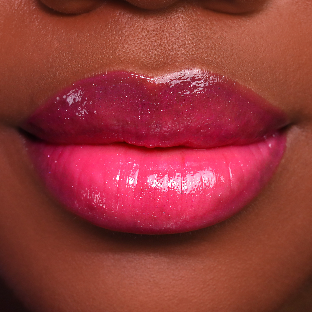 Just Cheeky berry pink lip gloss on lips, deep skin tone