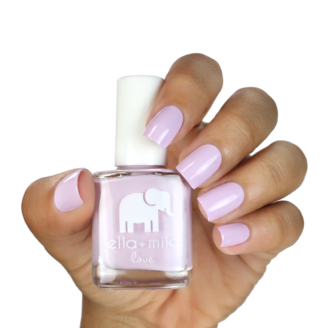 Lilac Luster light pastel purple nail polish on a medium skin tone, hand holding the bottle