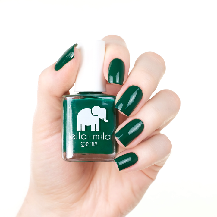 Mistletoe Magic holiday green nail polish manicure on a light skin tone with the bottle