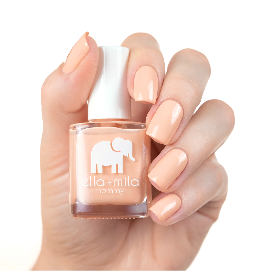 Nude Attitude peachy nude nail polish manicure on a light skin tone with the bottle