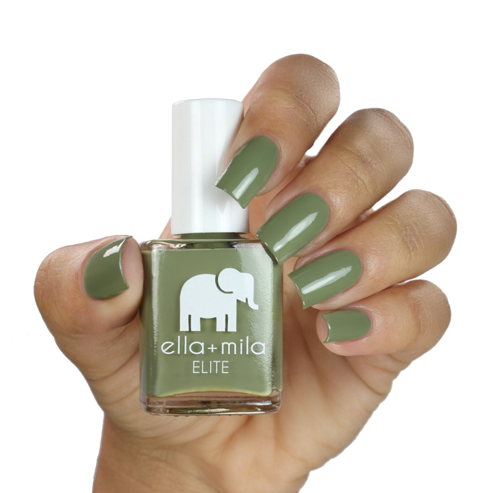 Paradise Isle army green nail polish on a medium skin tone, hand holding the bottle