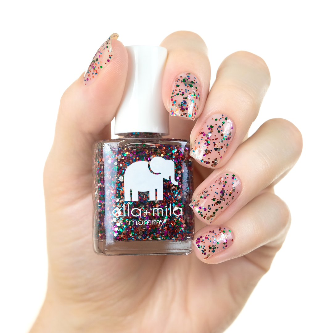 Party in a Bottle multicolor glitter nail polish over pink on a light skin tone, holding the bottle