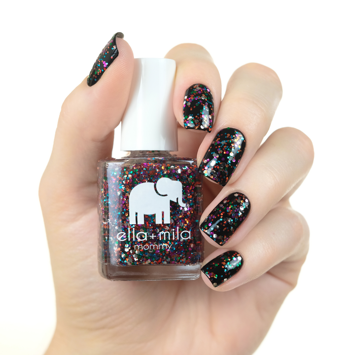 Party in a Bottle glitter nail polish layered over black on a medium skin tone