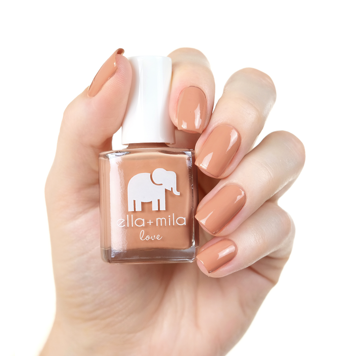 Sandy Toes nude peach caramel nail polish manicure on a light skin tone with the bottle