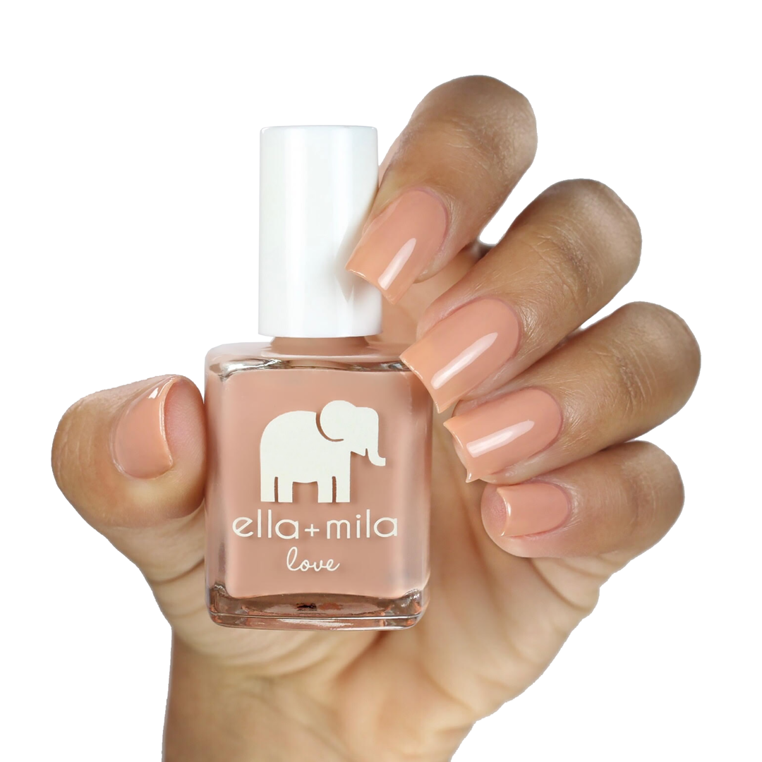 Sandy Toes nude caramel nail polish on a medium skin tone, hand holding the bottle
