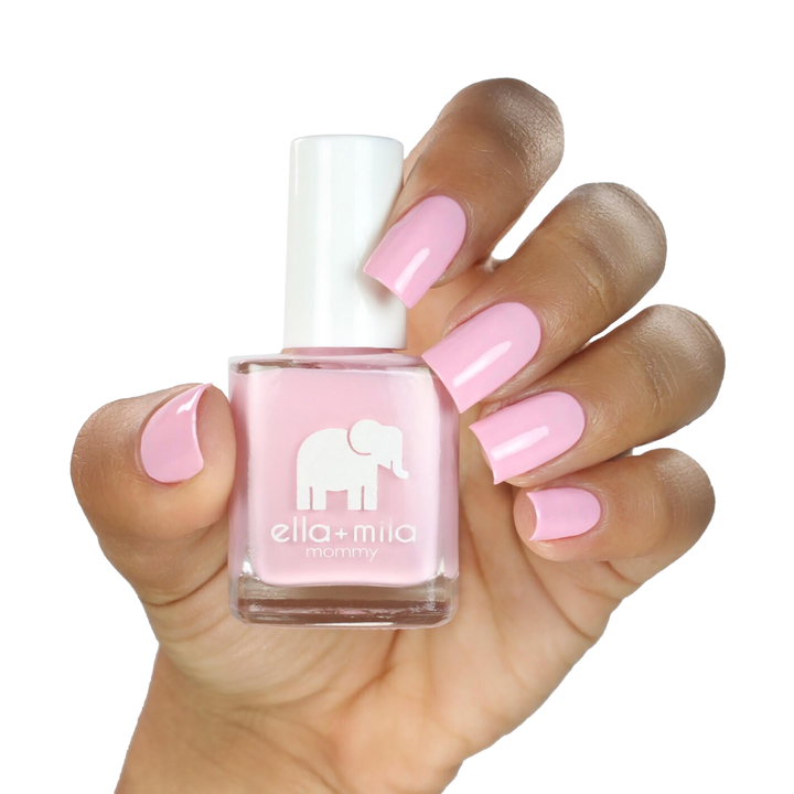 So in Love soft pink nail polish on a medium skin tone, hand holding the bottle